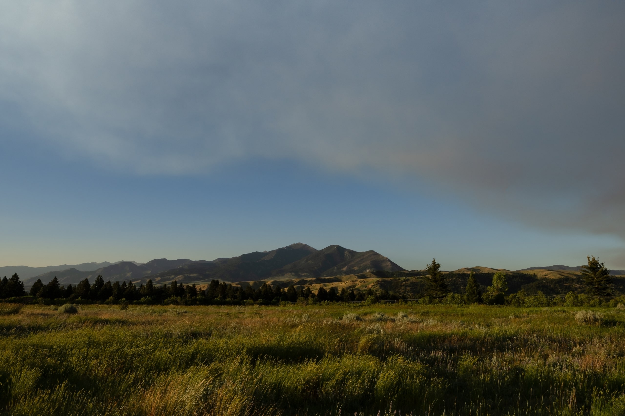 Clouds rolling in over Bozeman field with mountains